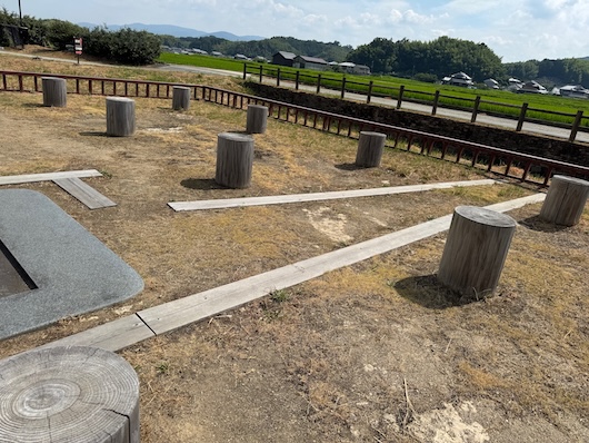 遺構の右手。柱位置の切り株が並び、左端に漏刻の座の台の一部。